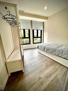 een slaapkamer met een bed en houten vloeren en ramen bij Apartamento Dama de noche in Córdoba