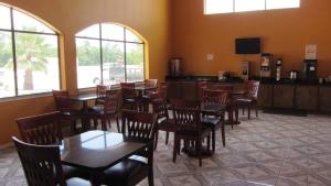 a dining room with tables and chairs and windows at Regency Inn Porter in Porter