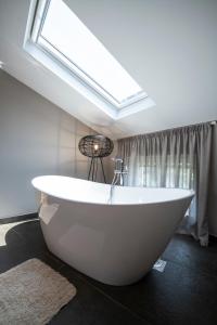 a white bath tub in a bathroom with a skylight at Villa Lav in Bale