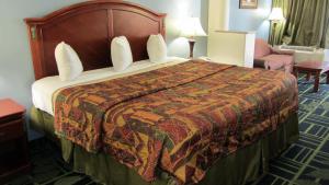 a hotel room with a large bed and a chair at Regency Inn Porter in Porter +16 photos