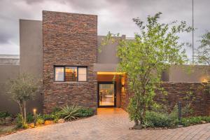 a brick house with a courtyard at Elephant Point in Skukuza