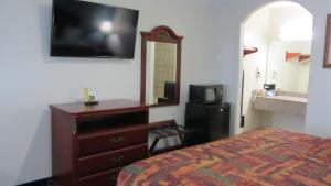 a bedroom with a bed and a dresser and a mirror at Regency Inn Porter in Porter