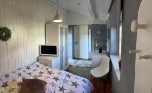 ein Schlafzimmer mit einem Bett, einem TV und einem Stuhl in der Unterkunft Ferienhaus Schmidt in Bernau am Chiemsee