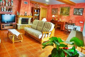 a living room with a couch and a tv at Casa Rural Salguero de Abajo in Dormón