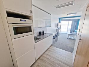 kuchnia z białymi urządzeniami i jadalnią w obiekcie Seaside Park Private Apartment by Villmaris w Kołobrzegu