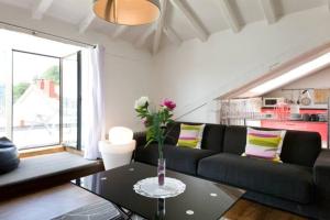 a living room with a black couch and a table at Pensión Iturriza in Donostia-San Sebastián