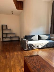 a living room with a couch and a wooden floor at L’ÉMERAUDE 2 in Chalons en Champagne