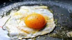 an orange sitting on top of an egg in a pan at En Plo Boutique Suites in Oia