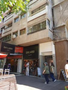 un grupo de personas caminando delante de un edificio en Peatonal Sarmiento en Mendoza