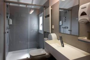 a bathroom with a shower and a sink and a toilet at Pensión Iturriza in Donostia-San Sebastián