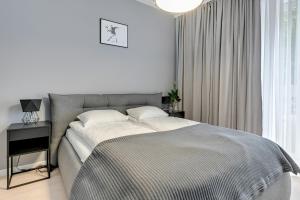 a bedroom with a bed and a table and a window at Old Town by Welcome Apartment in Gdańsk