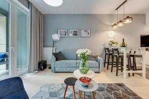 a living room with a blue couch and a table at Old Town by Welcome Apartment in Gdańsk