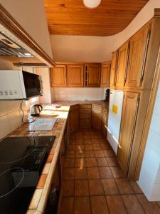 een keuken met houten kasten en een witte koelkast bij L’ÉMERAUDE 2 in Châlons-en-Champagne