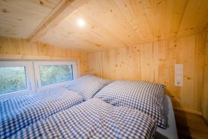 ein Bett in einem winzigen Haus mit Fenster in der Unterkunft Tiny House - Apfel in Wald