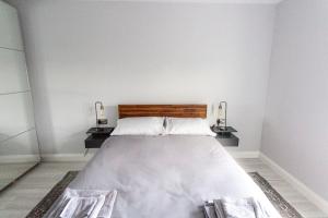 a bedroom with a large bed with two night stands at Causeway Coast Sea Front apartment - Ballycastle in Ballycastle