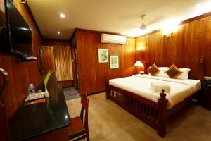 een slaapkamer met een groot bed en houten wanden bij Hotel Mahabs in Mahabalipuram