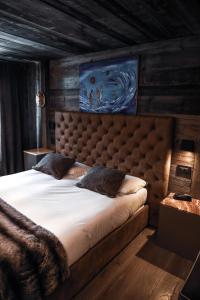 ein Schlafzimmer mit einem großen Bett mit einem großen Kopfteil in der Unterkunft Art Hotel Grivola in Breuil-Cervinia