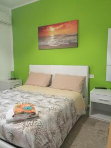 - une chambre dotée d'un lit avec un mur vert dans l'établissement Le Magnolie B&B, à Roseto degli Abruzzi