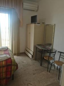 a small room with a table and a refrigerator at Le Magnolie B&B in Roseto degli Abruzzi