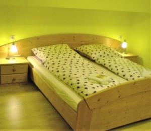 a wooden bed with two night stands and two lamps at Landhaus - Neubauer in Schladming