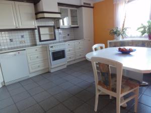 una cocina con armarios blancos y una mesa con un bol de fruta. en Apartment Elena, en Gedersdorf