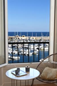 een kamer met een tafel en uitzicht op een jachthaven bij Sognu di Matteu - Bel appartement entièrement climatisé - vue mer, vieux port Bastia in Bastia