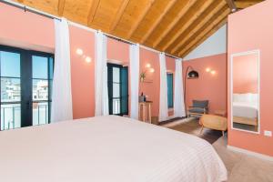 a bedroom with a large white bed and large windows at Casa Rosa Villa with Pool in Olhao Centre in Olhão