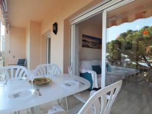 een eetkamer met witte tafels en witte stoelen bij Apto vista a mar para 4 pax en caoca d27010 in S'Agaro