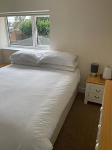 a bed with white sheets and a window in a room at Anchor Inn in Kempsey
