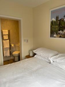 a bedroom with a white bed and a toilet at Anchor Inn in Kempsey