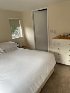 a bedroom with a large white bed and a dresser at Anchor Inn in Kempsey