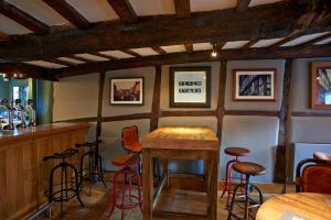 a bar with stools and a table in a room at Seven Stars in Ledbury