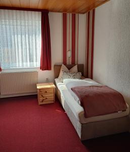 une petite chambre avec un lit et une fenêtre dans l'établissement Hotel und Restaurant Hohenzollern, à Erfurt