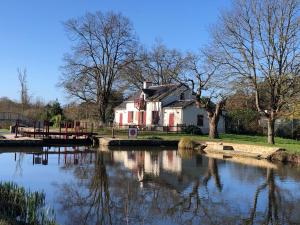 a house sitting next to a body of water at Ecluse de la Tindière in Nort-sur-Erdre