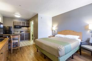 a bedroom with a large bed and a kitchen at Studio 6-Tempe, AZ in Tempe