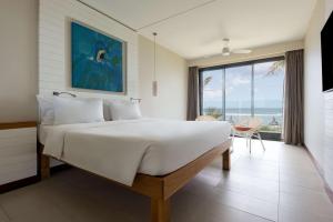 a bedroom with a large bed with a view of the ocean at Radisson Blu Poste Lafayette Resort & Spa (Adults Only) in Poste Lafayette