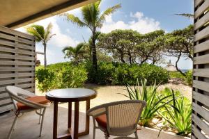 a patio with a table and chairs and the beach at Radisson Blu Poste Lafayette Resort & Spa (Adults Only) in Poste Lafayette +37 photos