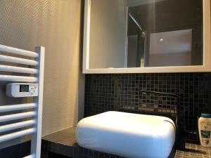 een badkamer met een witte wastafel en een spiegel bij Studio Brest centre ville, 3ème étage sans ascenseur in Brest