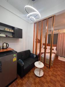 ein Wohnzimmer mit Sofa und Bett in der Unterkunft Acozyposhtel in Bangkok