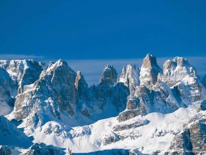 eine Gruppe von schneebedeckten Bergen in der Unterkunft Le Marmotte del Brenta in Carisolo