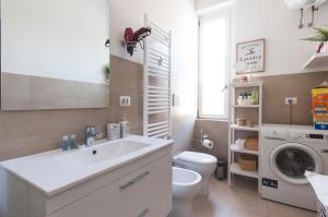 uma casa de banho com um lavatório e uma máquina de lavar roupa em YouHosty - Algardi 5 em Milão