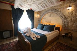 een slaapkamer met een groot bed en een groot raam bij Akritis suit Cappadocia in Çadır