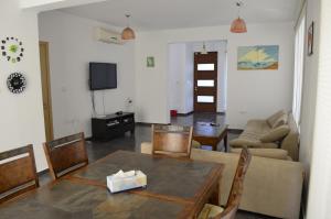 a living room with a table and a couch at Fleur De Mer Villa in Hi-Tech Style in Limassol