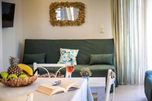 a living room with a table and a green couch at Τrilogy Studios in Syvota