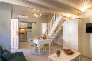 a kitchen and dining room with a table and stairs at Τrilogy Studios in Syvota