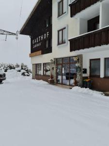 a building with snow on the ground in front of it at Gasthof Lublass in Matrei in Osttirol