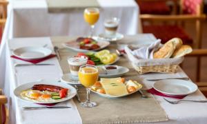 stół z talerzami jedzenia i kieliszkami soku pomarańczowego w obiekcie Hotel Árpád w mieście Tatabánya