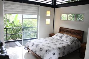 a bedroom with a bed and a large window at Finca Hotel Villa Cristina in La Mesa