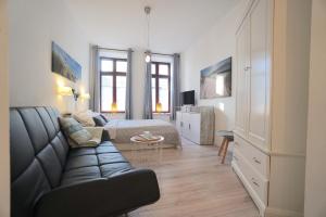 a living room with a couch and a bed and a television at Apartment THOR am Schleswiger Dom in Schleswig