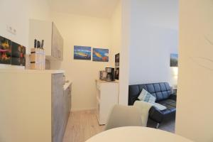 a living room with a blue couch and a kitchen at Apartment THOR am Schleswiger Dom in Schleswig
